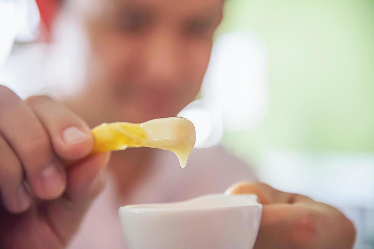 Man show French fries dip in cream sauce photo