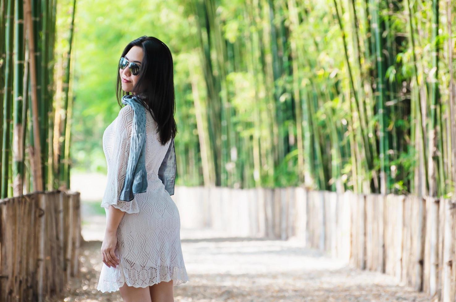 mujer feliz de pie felizmente en el bosque de bambú en medio cuerpo foto