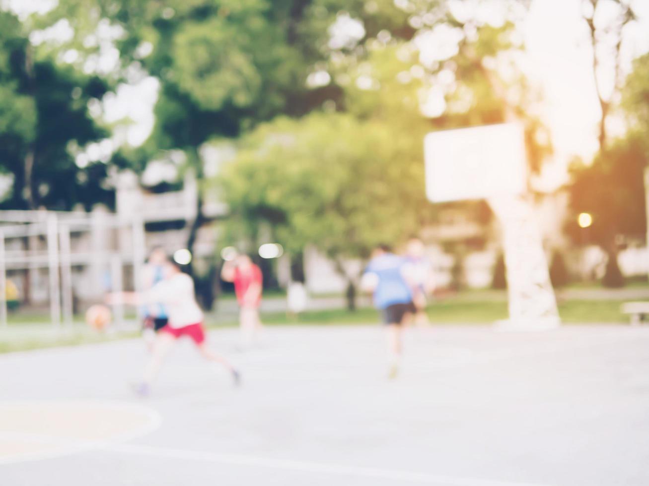 Blurred photo of Asian children are playing basketball with warm sun light from top right corner