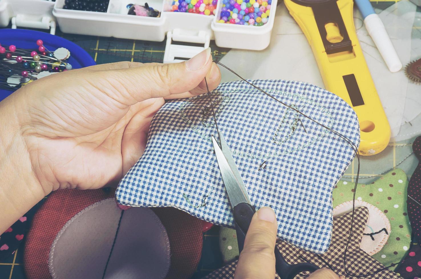una mujer está haciendo costura con otro equipo de bordado en una mesa foto