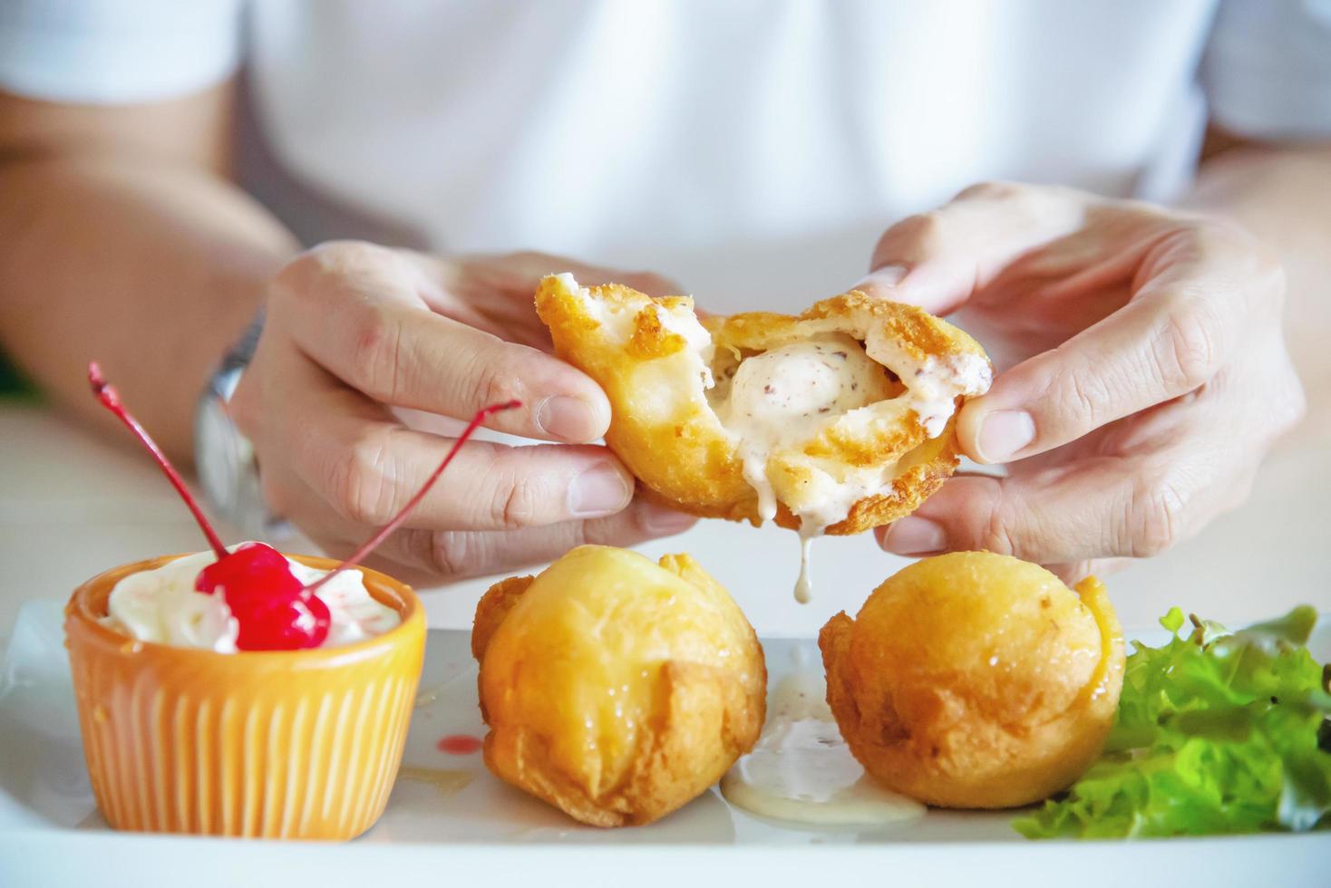 Man going to eat colourful fried ice cream ball dish - people with fast delicious unhealthy food concept photo