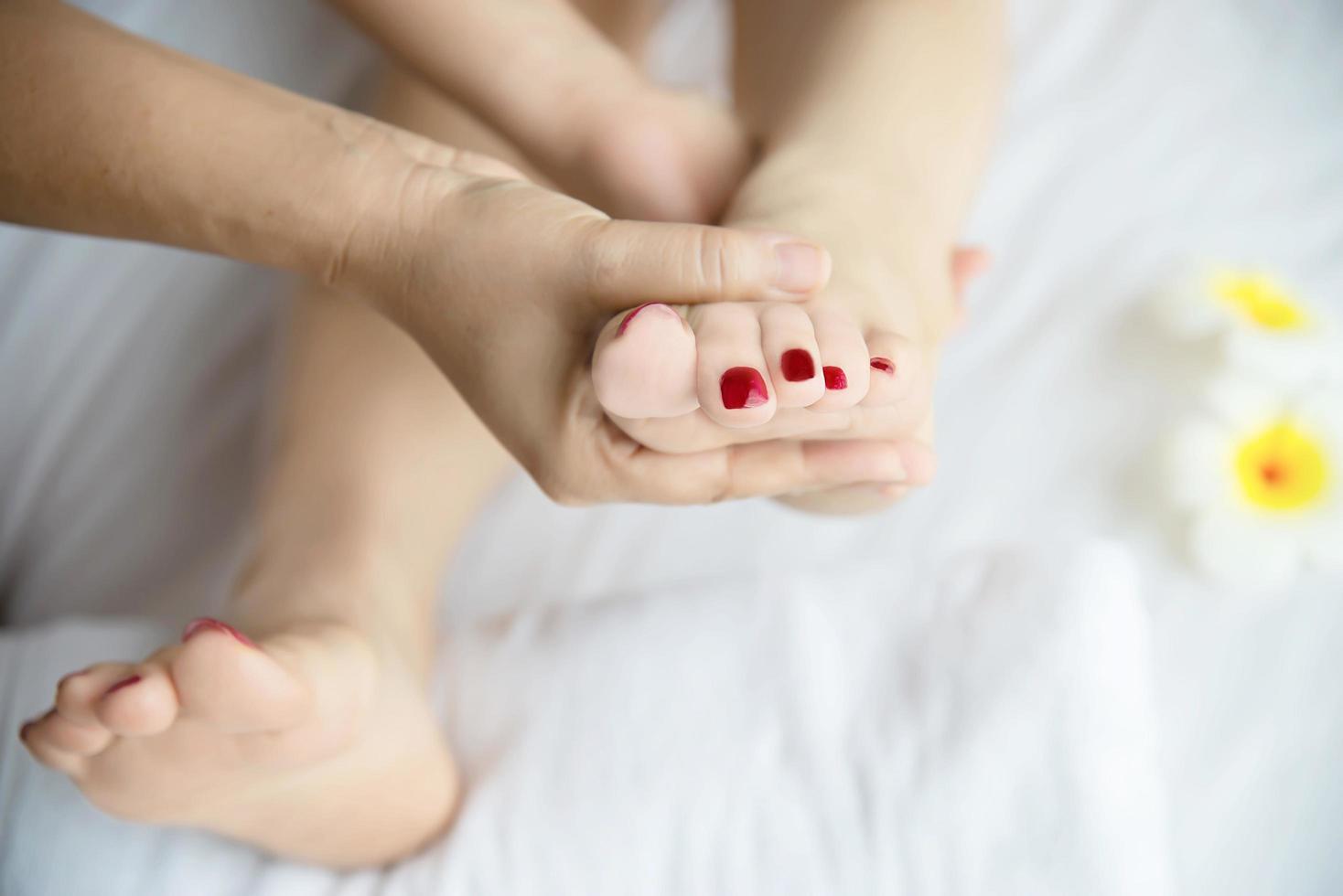 Woman receiving foot massage service from masseuse close up at hand and foot - relax in foot massage therapy service concept photo