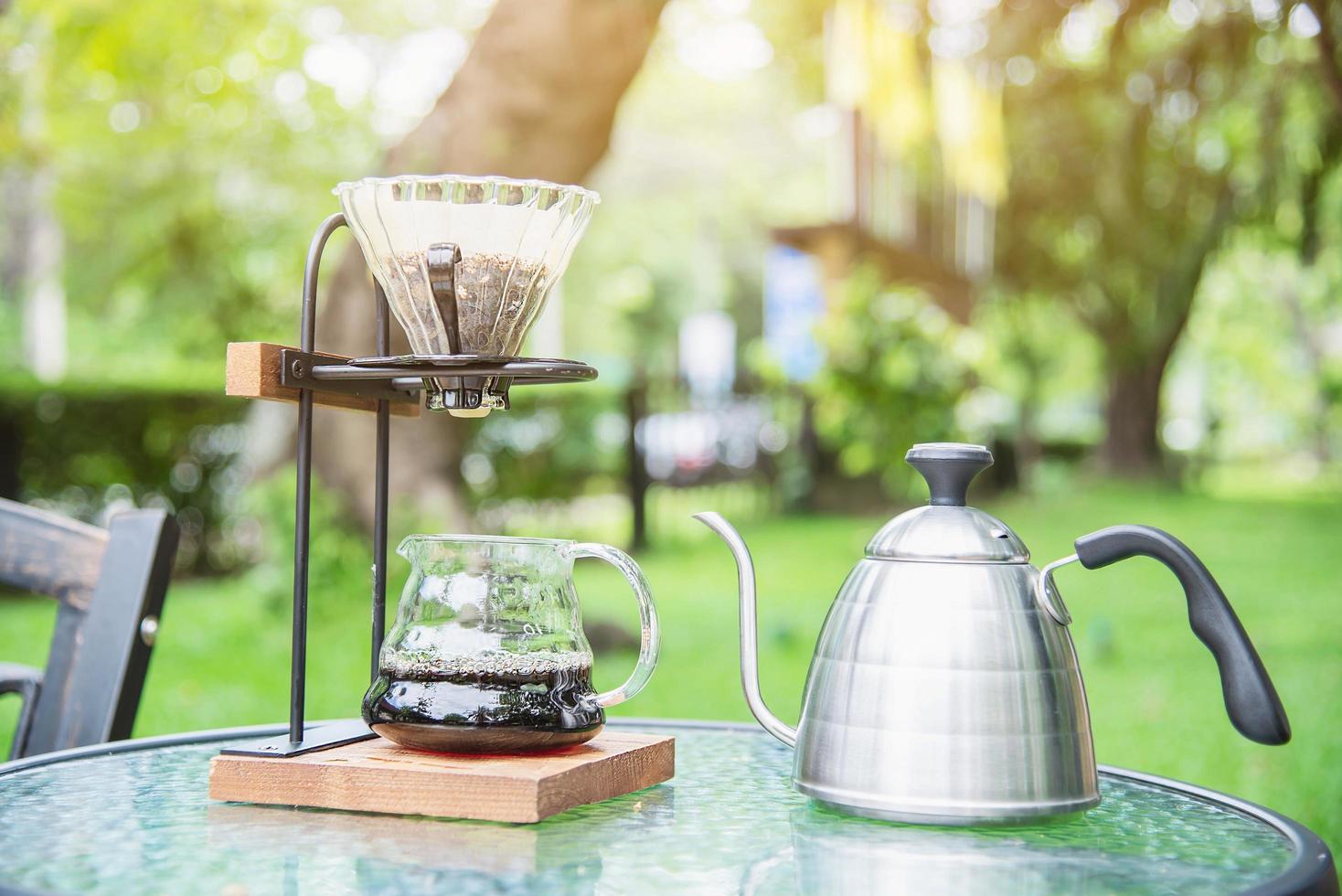 Making drip coffee in vintage coffee shop with green garden nature background - fresh coffee in nature concept photo