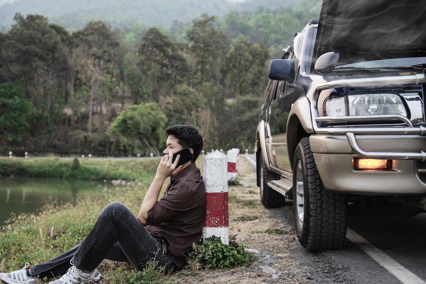 Man try to fix a car engine problem on a local road Chiang mai Thailand - people with car problem transportation concept photo