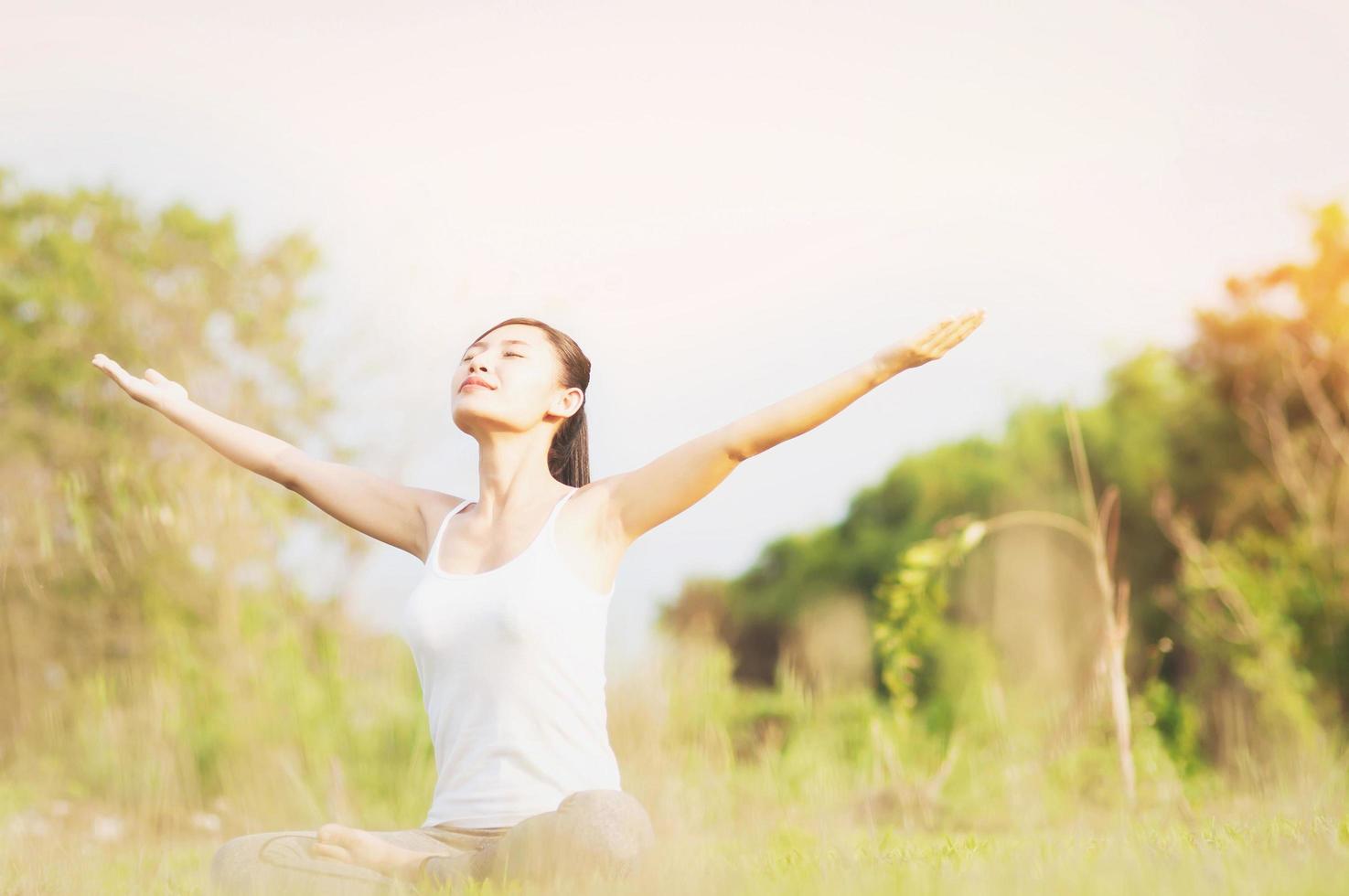 señorita haciendo ejercicio de yoga en el campo verde al aire libre mostrando calma pacífica en la mente de meditación - la gente practica yoga para la meditación y el concepto de ejercicio foto