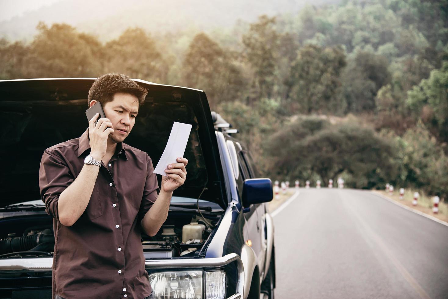 Man try to fix a car engine problem on a local road Chiang mai Thailand - people with car problem transportation concept photo