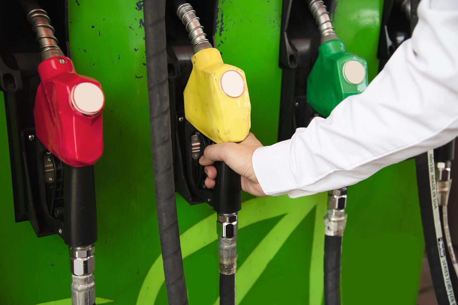 Man putting gasoline fuel into his car in a pump gas station photo