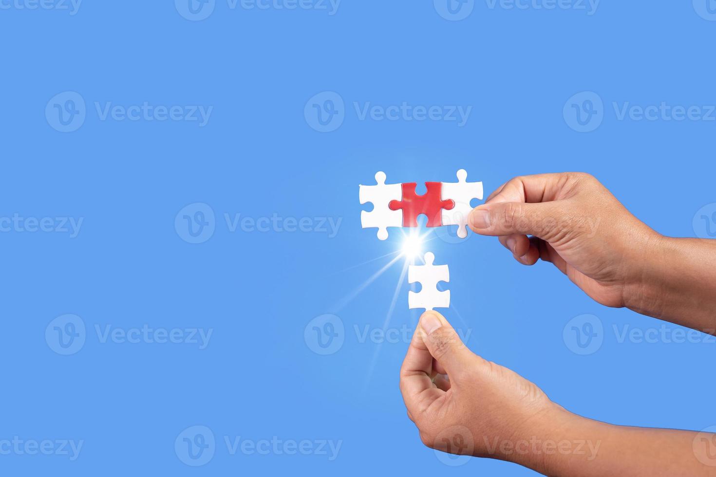 Hands holding jigsaw puzzles piece with clear blue background, success business, solution strategy, teamwork partnership concept photo