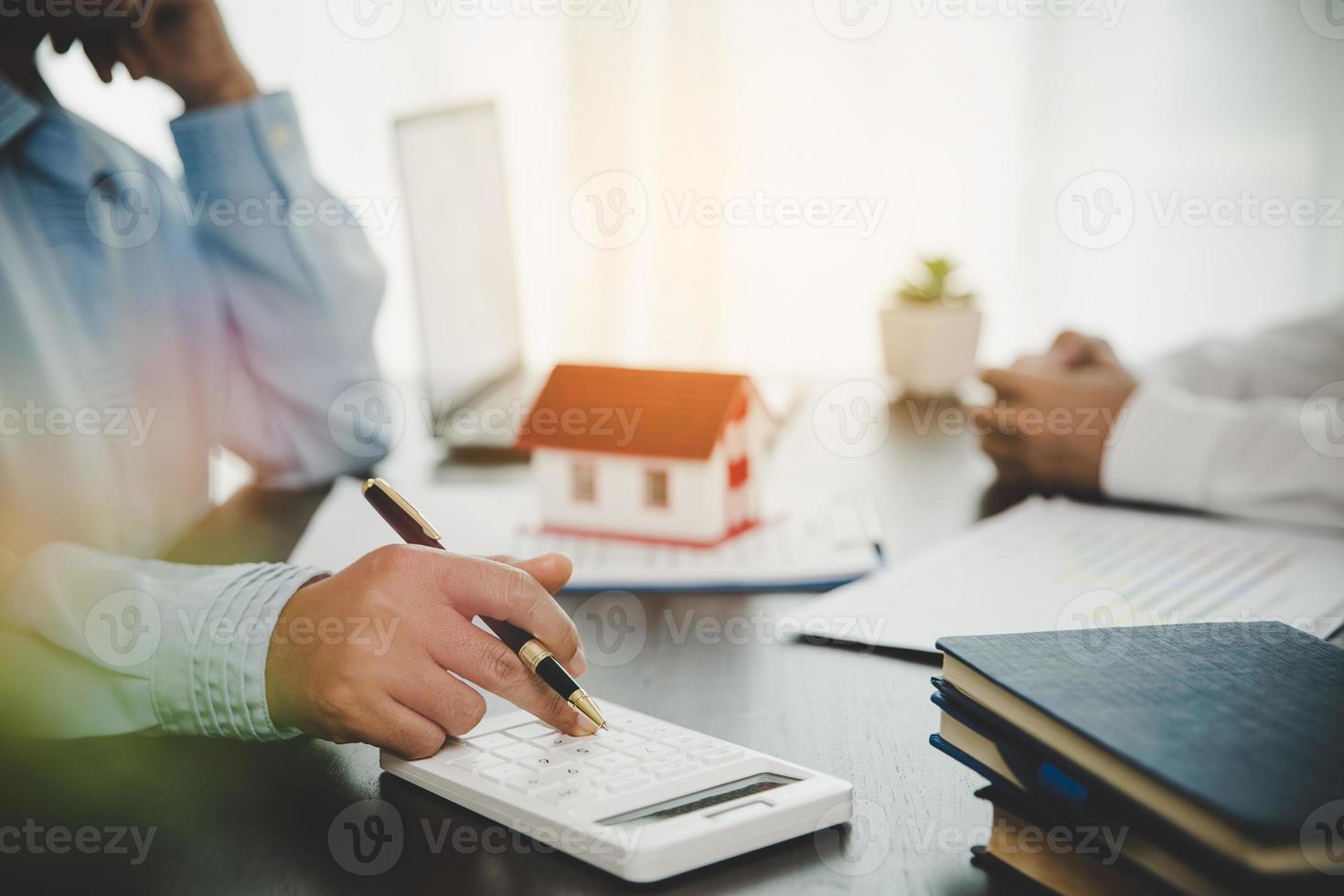 Real estate broker agent presenting and consult to customer to decision making sign insurance form agreement, home model, concerning mortgage loan offer for and house insurance. photo