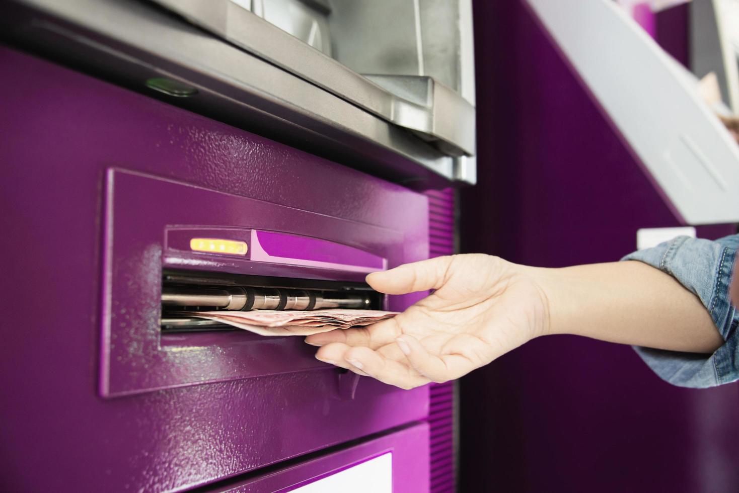 People waiting to get money from automated teller machine - people withdrawn money from ATM concept photo
