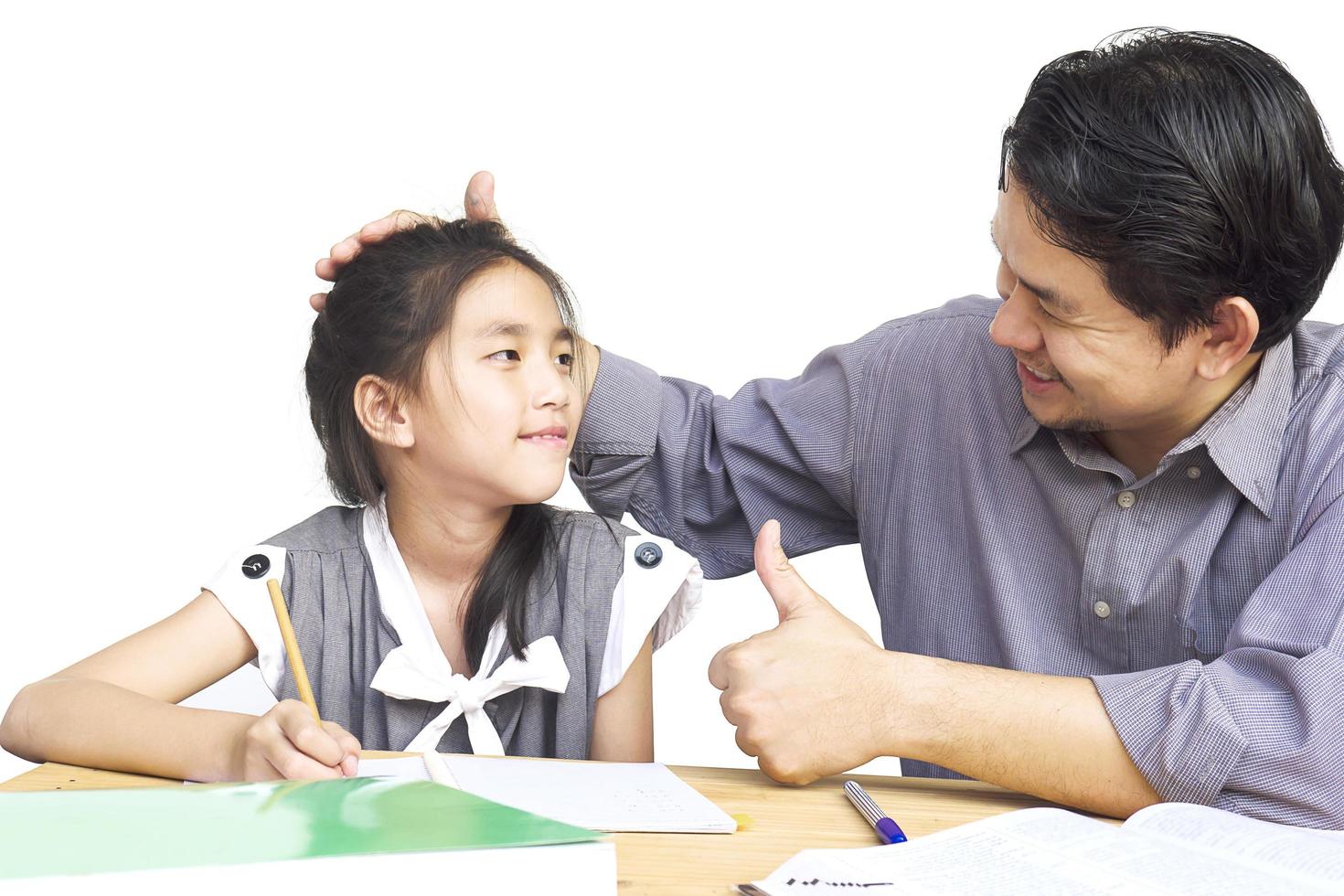 papá enseñando a su hijo mientras hace la tarea foto