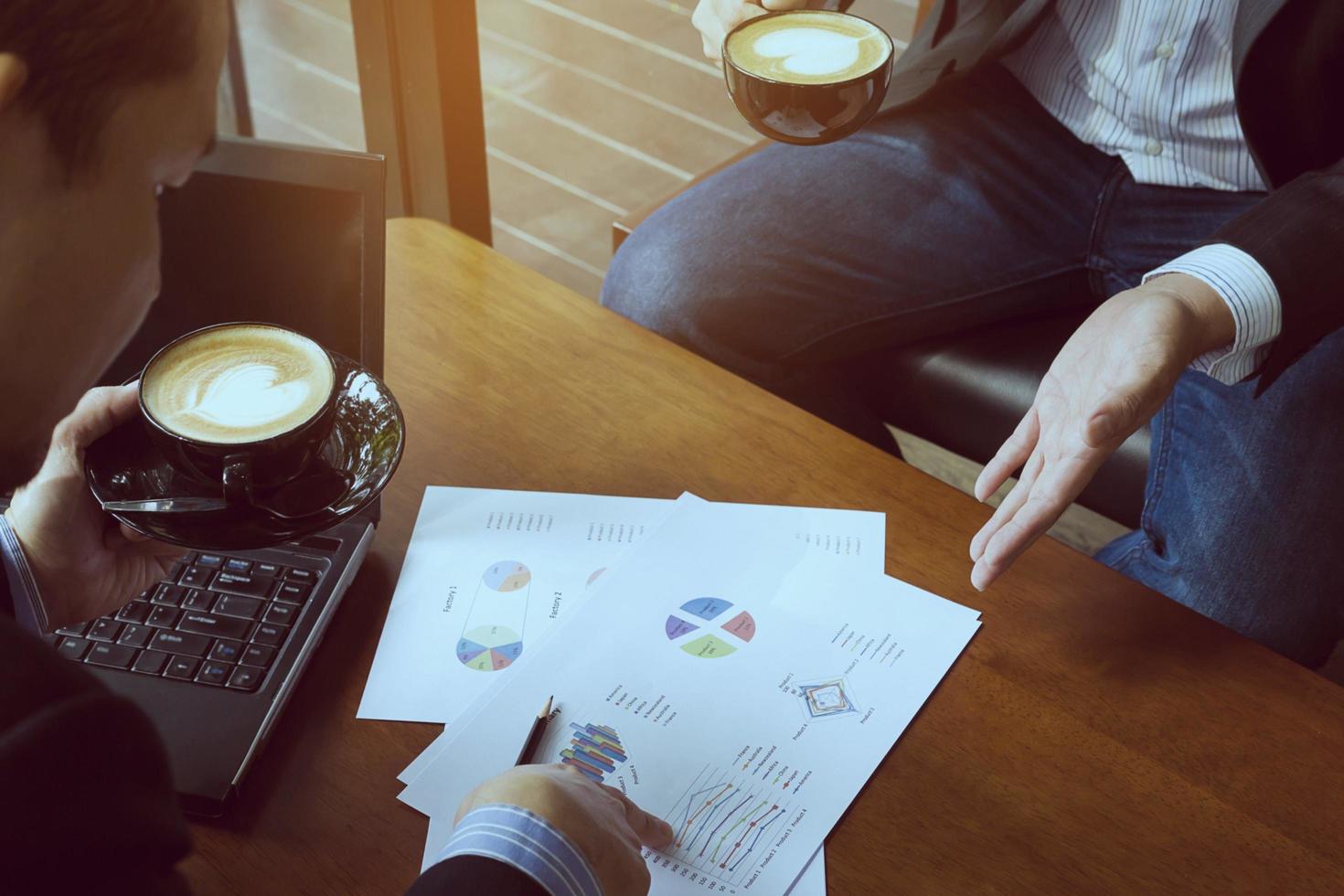 Two businessman discussing their chart in coffee shop photo