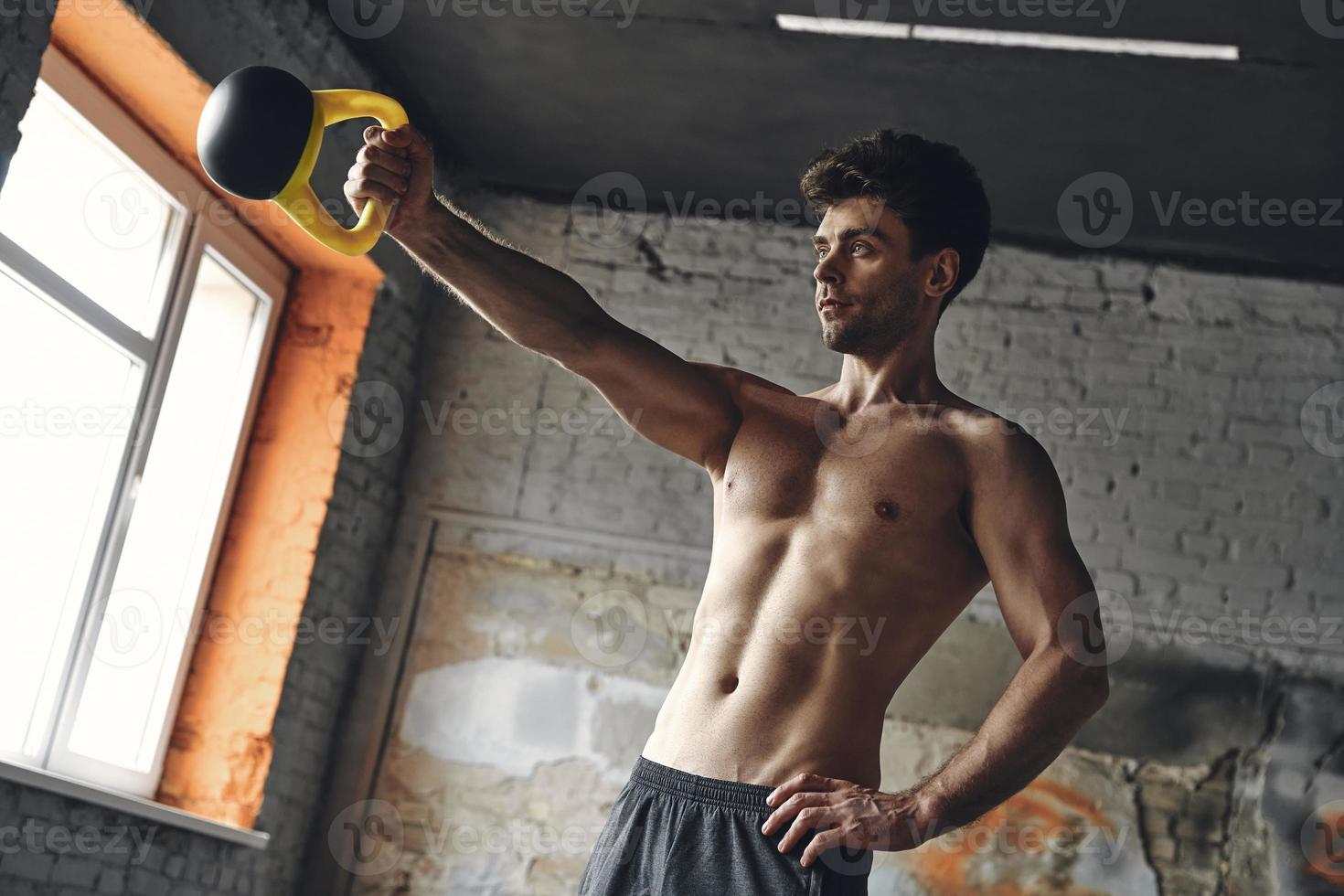Hombre leyendo muscular para entrenar con kettle ball en el gimnasio  crossfit Fotografía de stock - Alamy