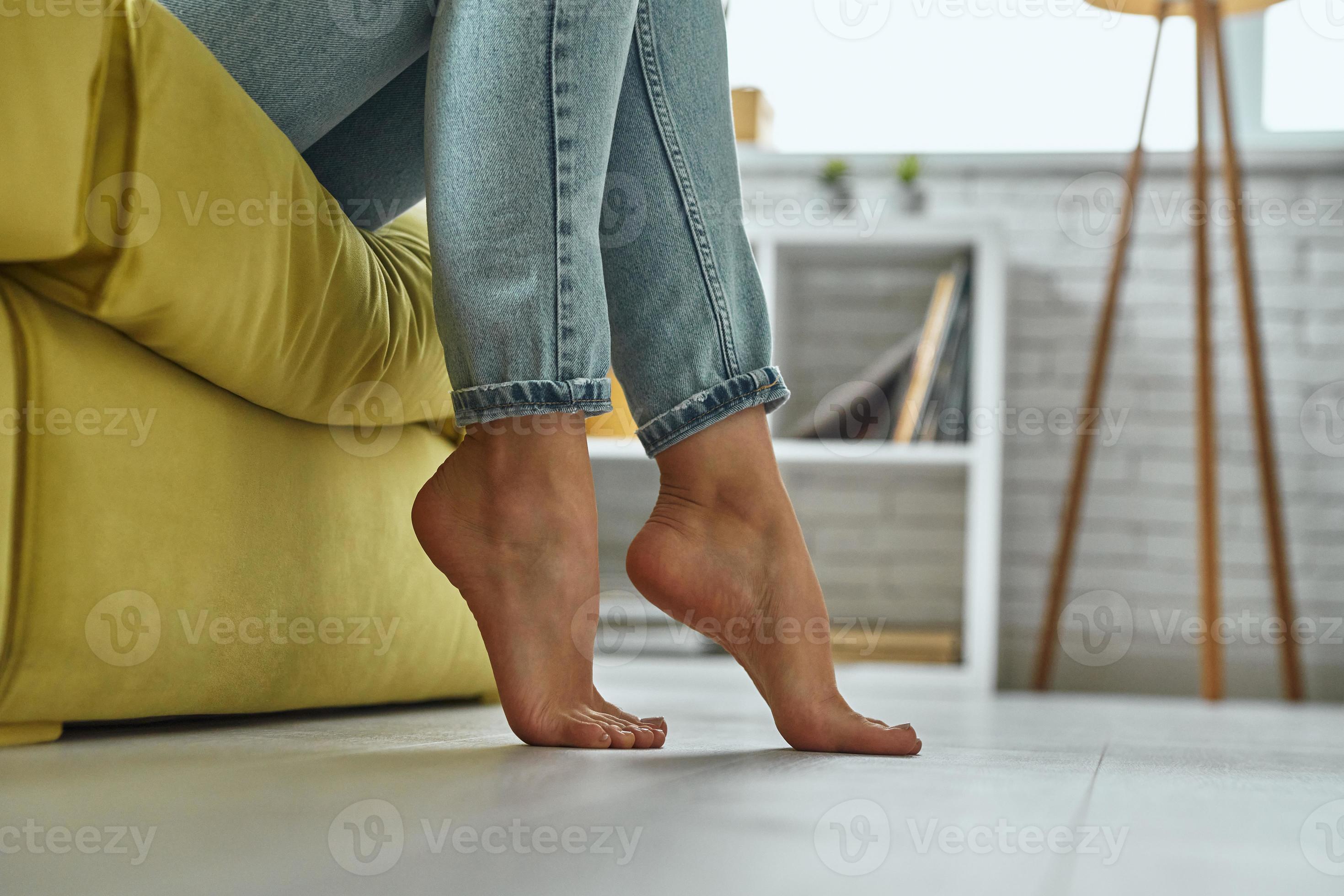 Closeup of female feet touching warm wooden floor at home 10175869