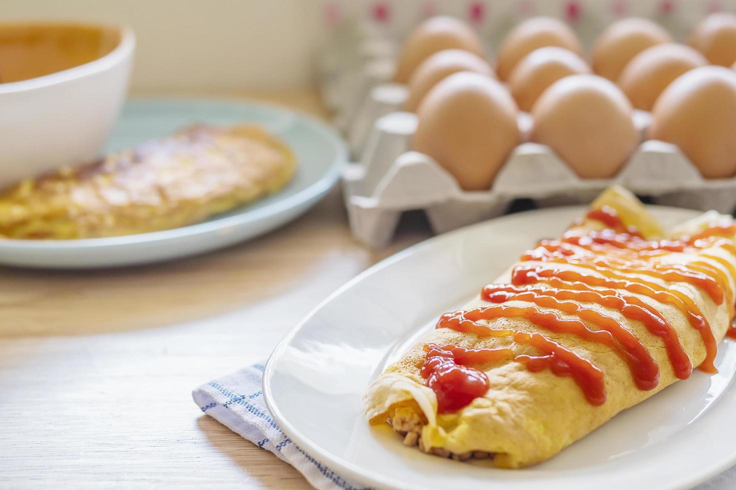 Omelette with ketchup on top in a white plate with a blur egg tray as a background photo