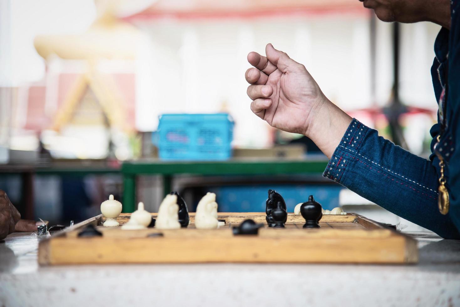 Local Thai people play old traditional Thai chess in public area - slow life style local people with chess board game concept photo