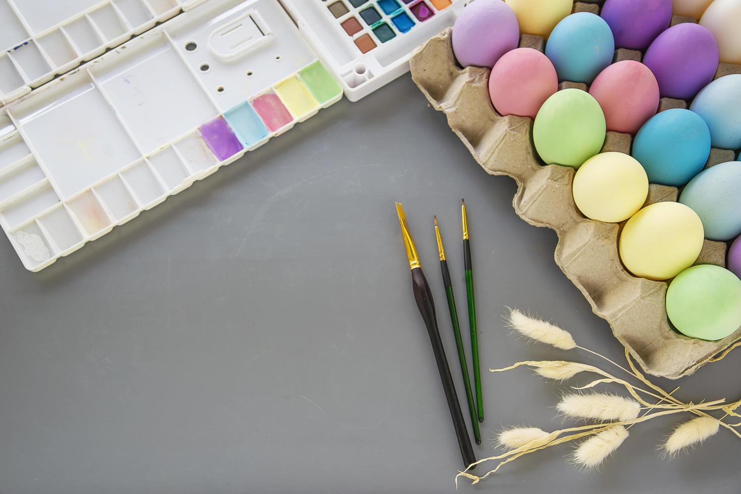 gente pintando coloridos huevos de pascua - concepto de celebración de vacaciones de pascua foto