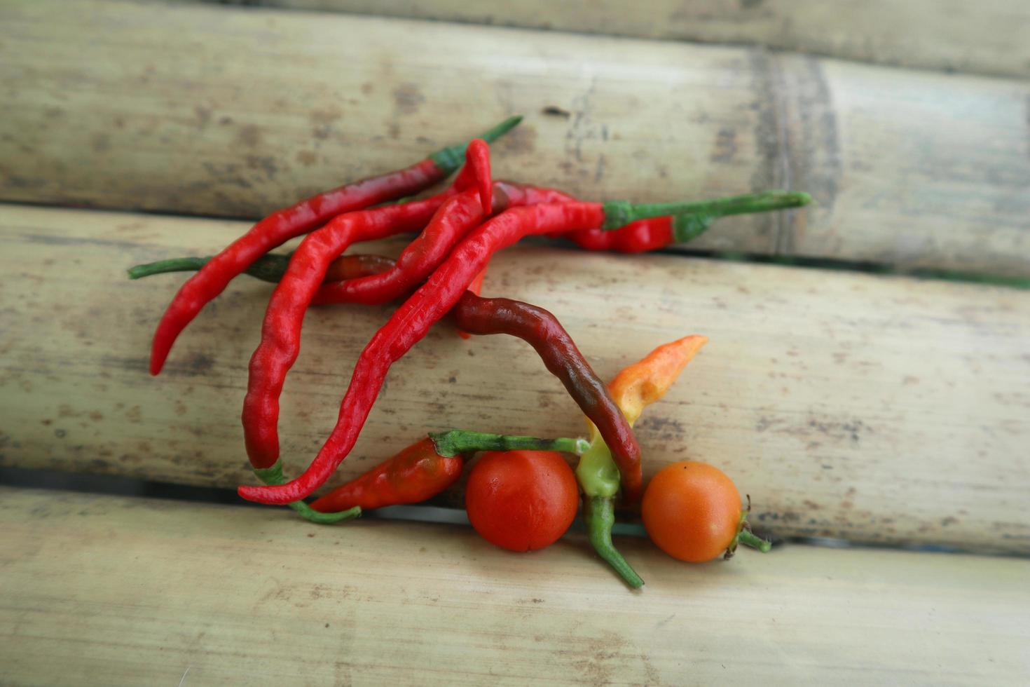 Hot chili peppers isolated on bamboo. Red and green Chile peppers plant photo