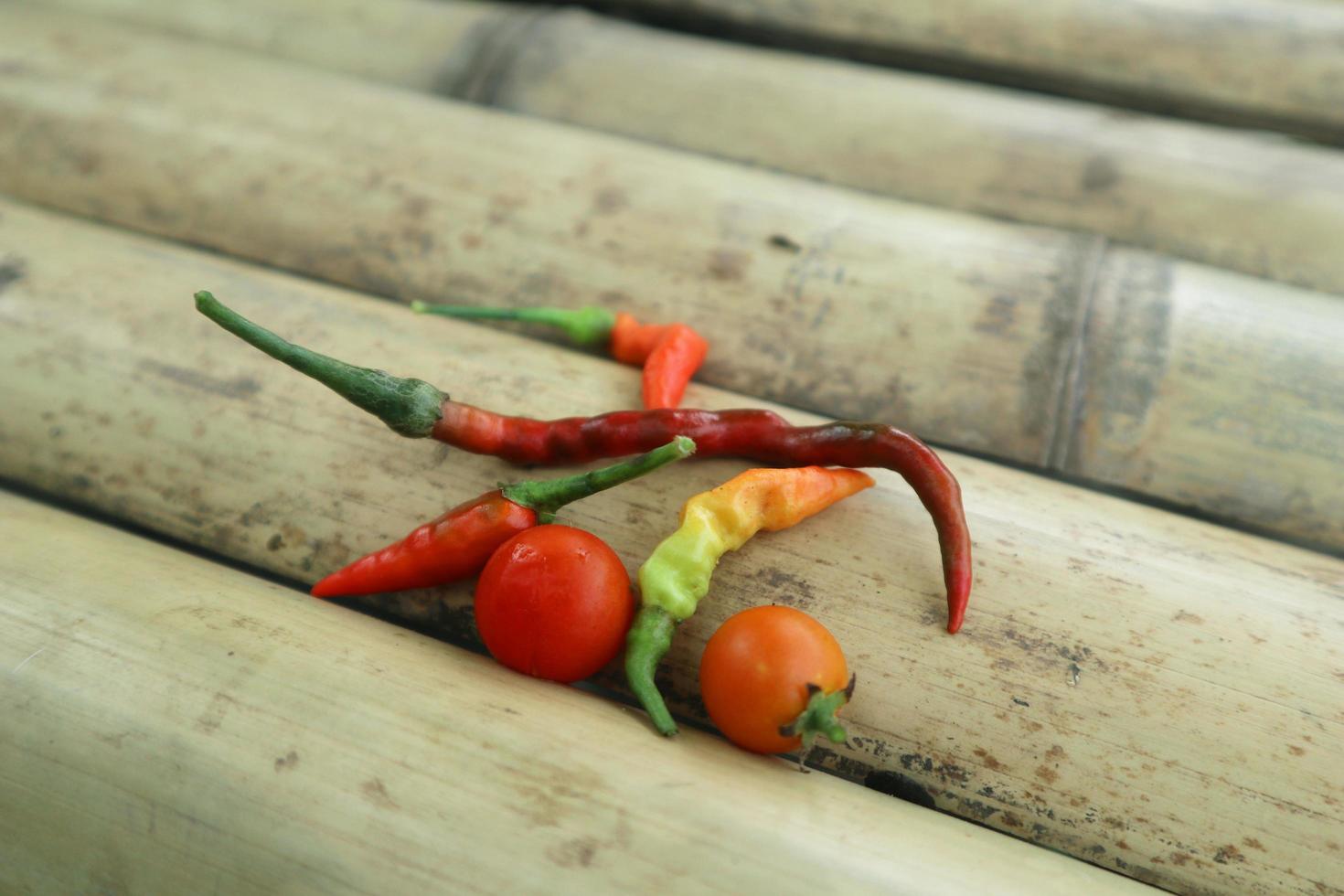 Hot chili peppers isolated on bamboo. Red and green Chile peppers plant photo