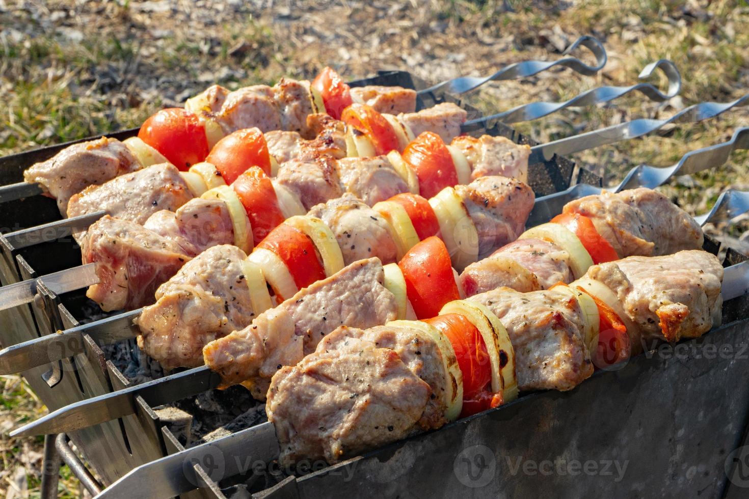 Grilling marinated shashlik preparing on a barbecue grill over charcoal.  Shashlik is a form of Shish kebab popular in Eastern Europe. Shashlyk (meaning  skewered meat) was originally made of lamb. Stock Photo