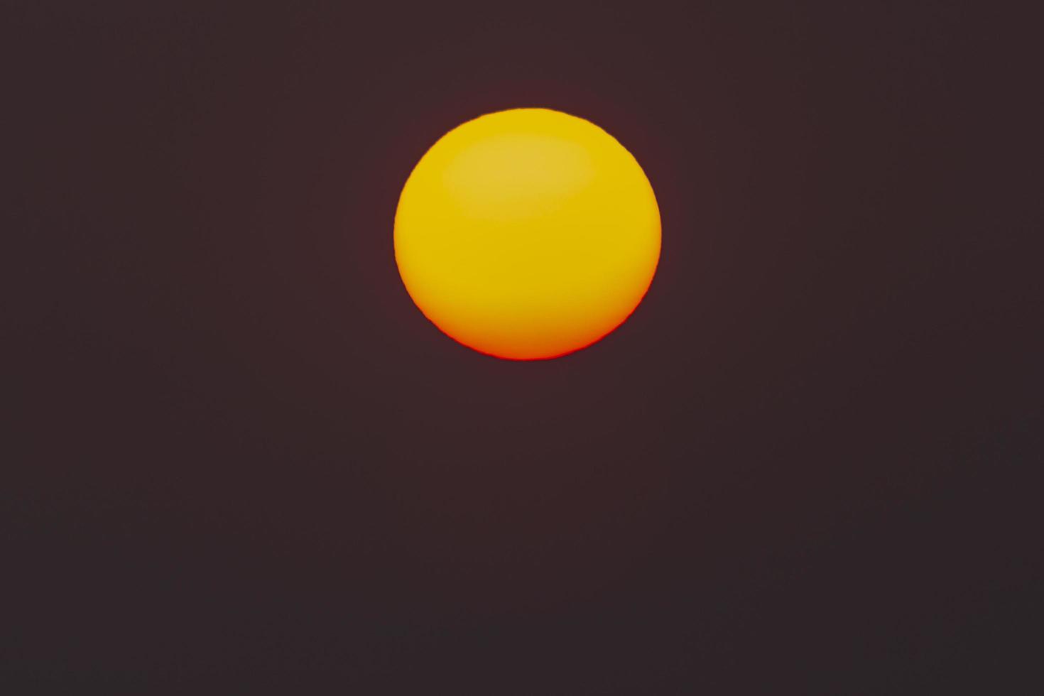 The evening or morning sun can be seen with the naked eye. The sun is red because of the dust and atmosphere. photo