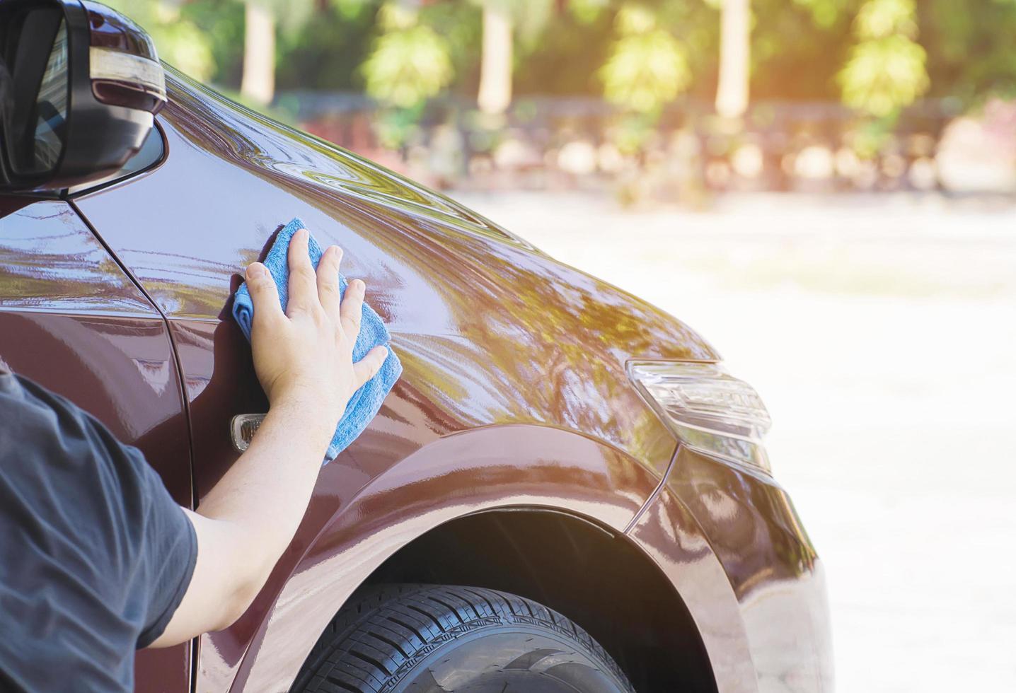 Man's hand is cleaning and waxing the car photo