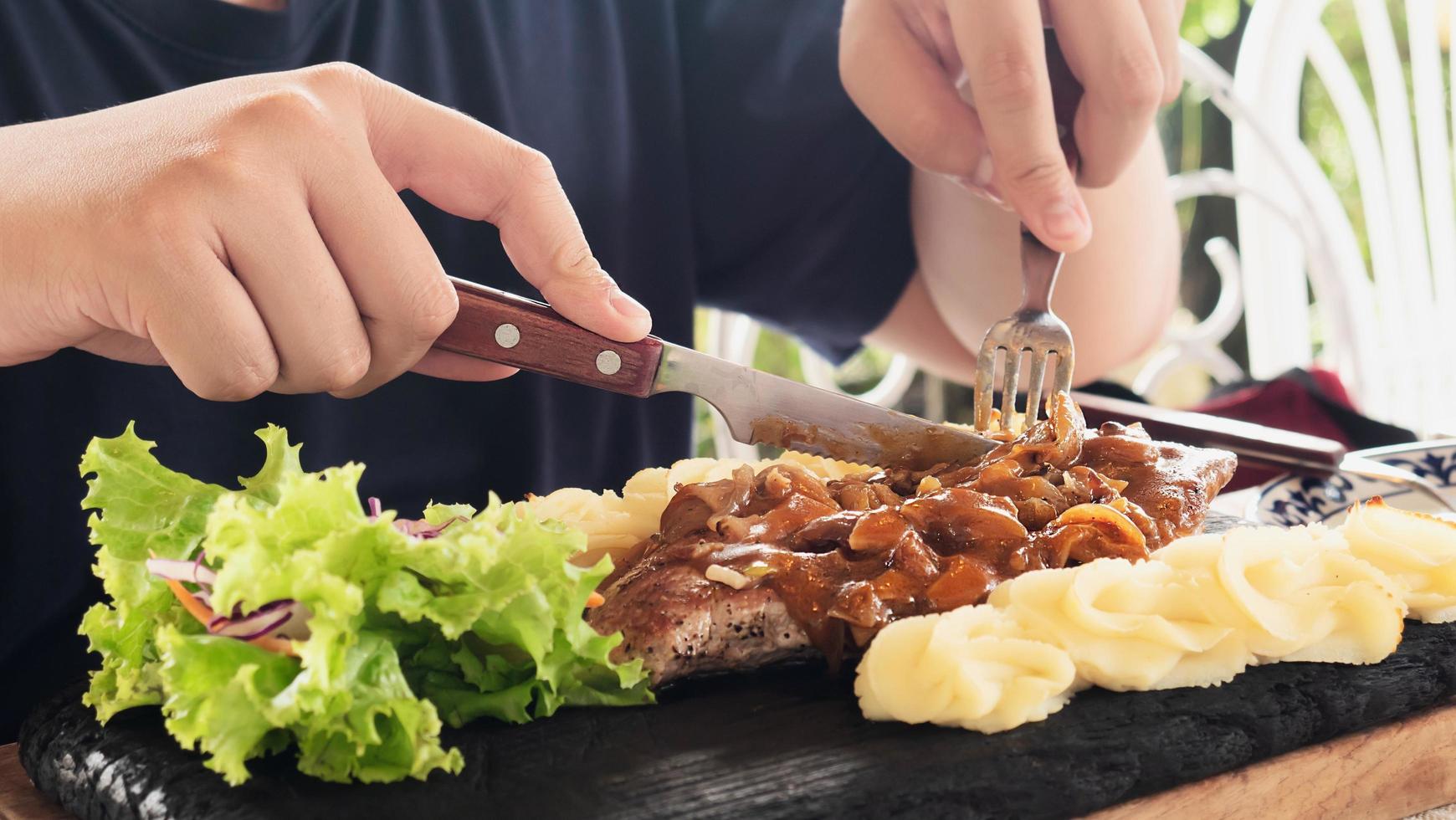 Man eating pork steak recipe - people with a colourful delicious steak international dish concept photo