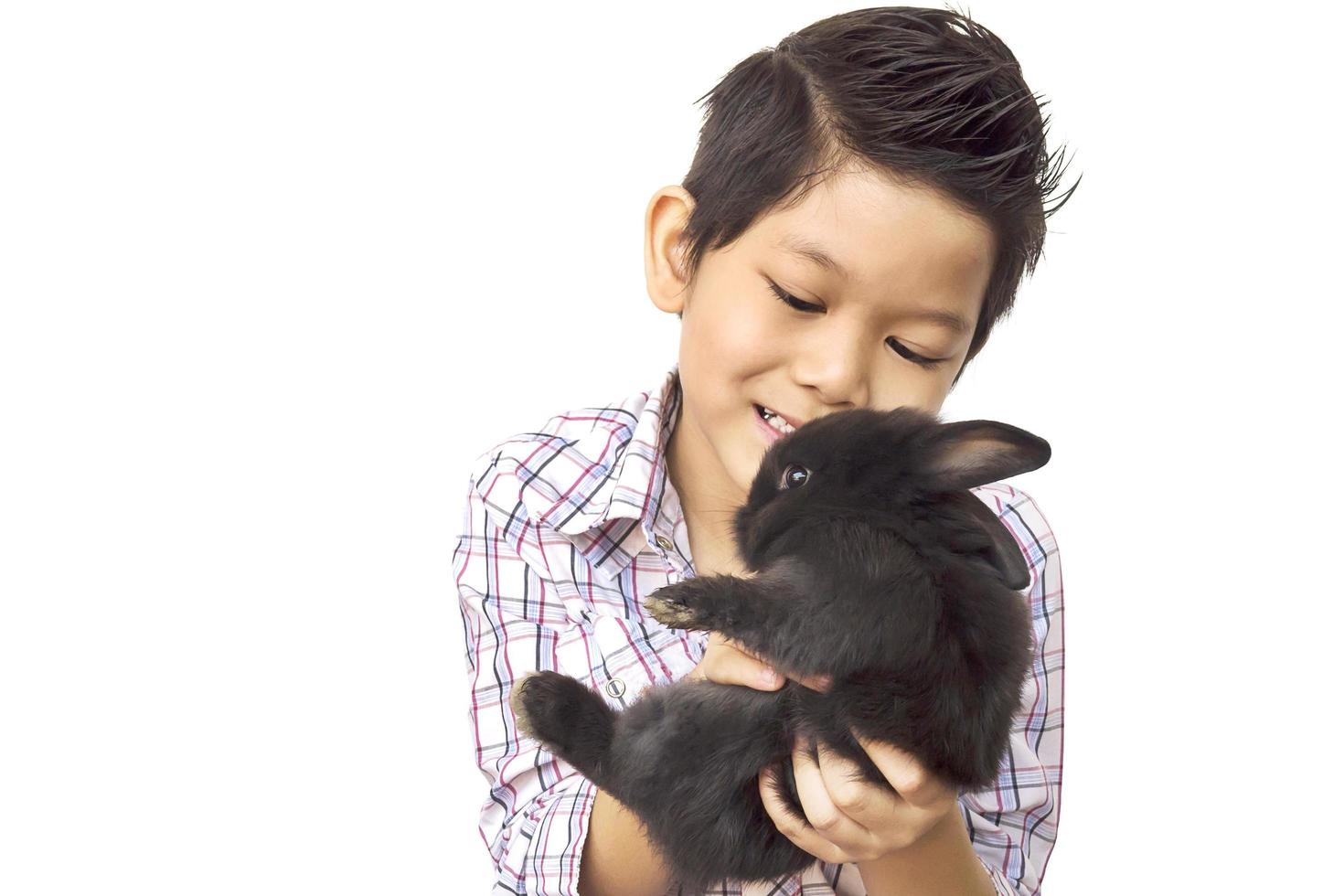 Asian kid playing with lovely baby rabbit isolated over white photo