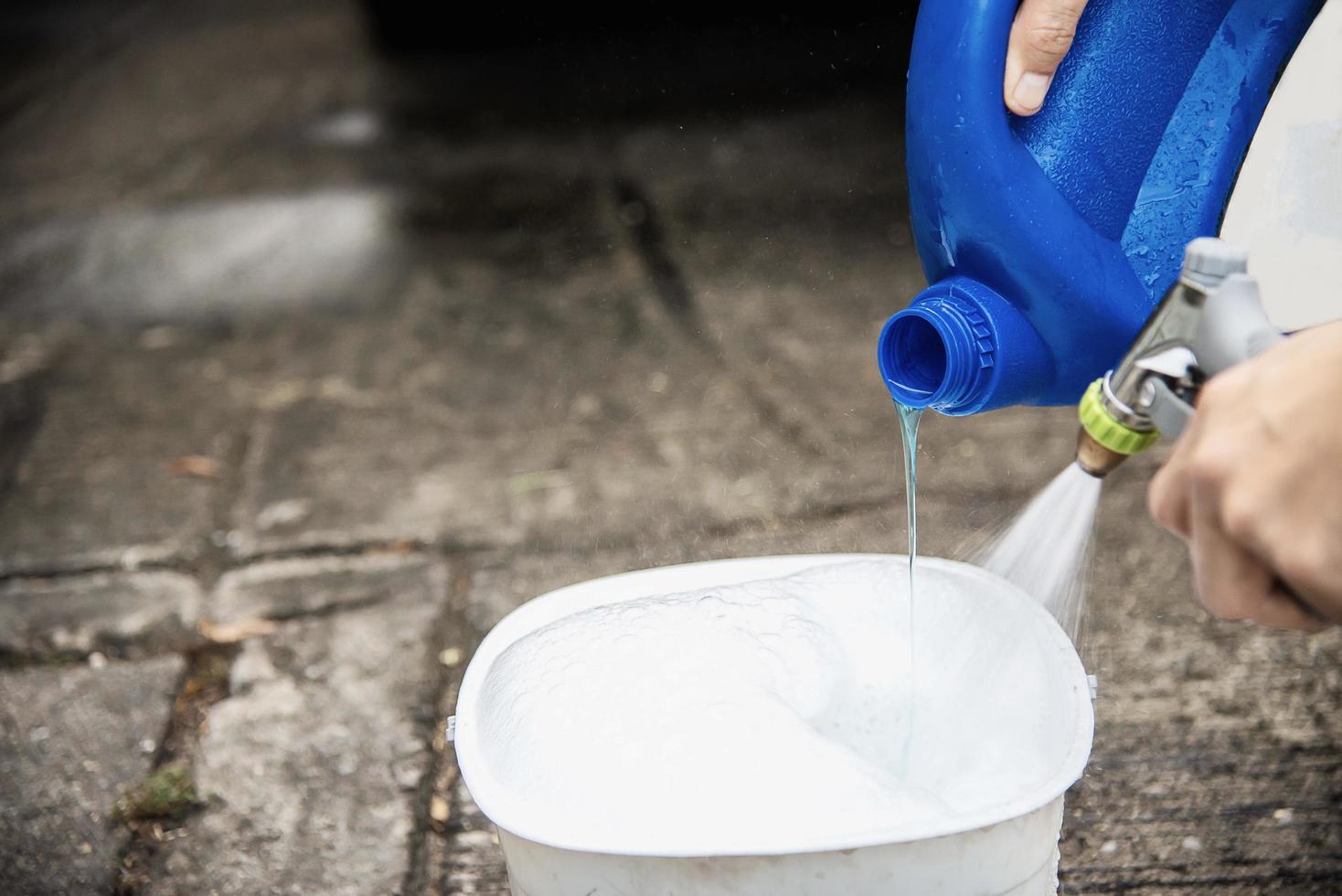 Man prepare shampoo water for washing car using - home people car clean concept photo