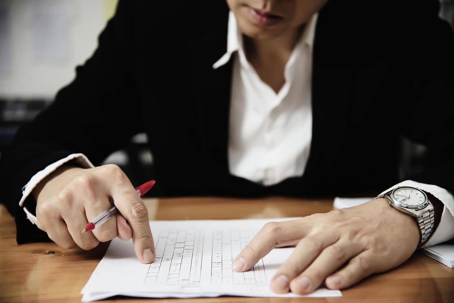 Instructor checking multiple choices answer sheet exam - education people working with paper test concept photo