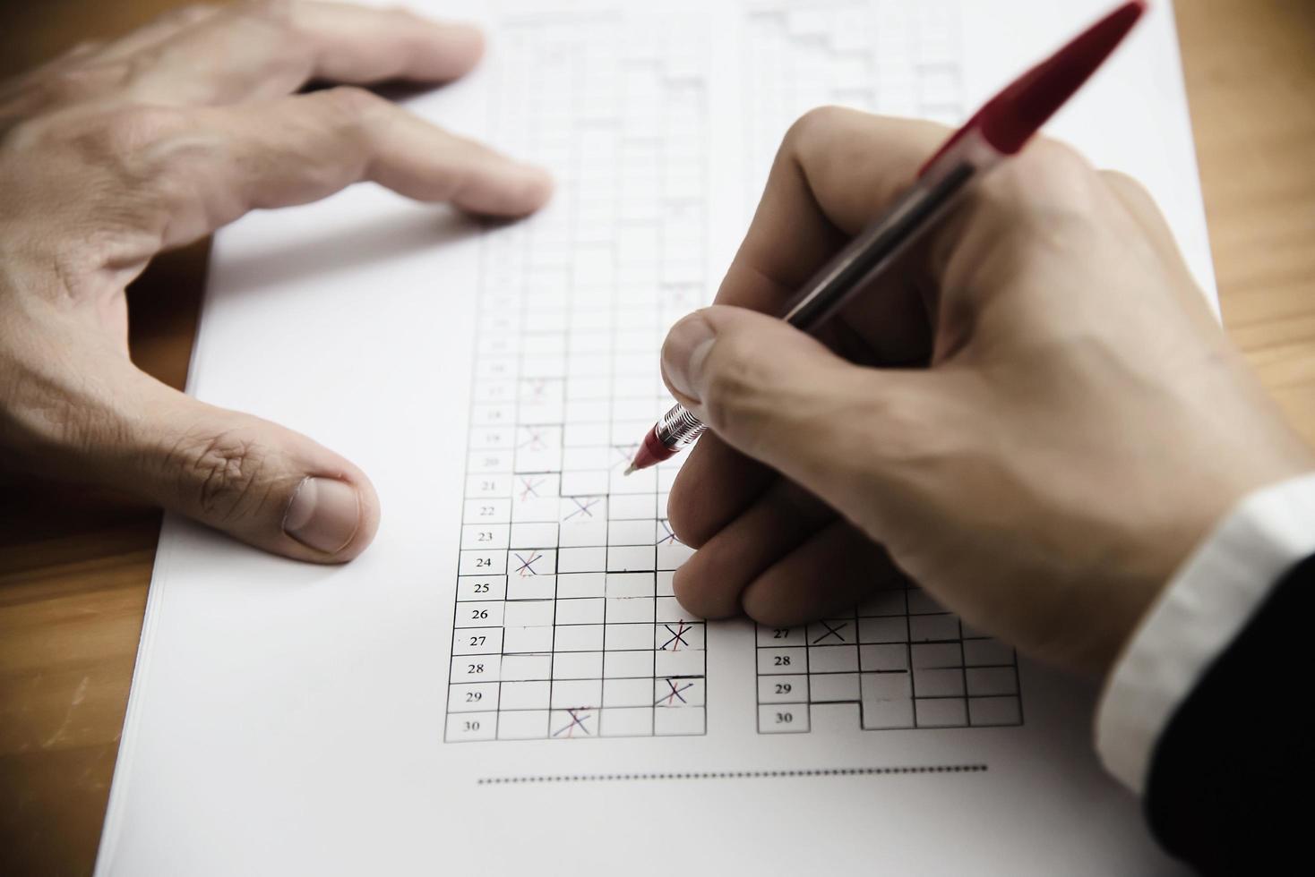 Instructor revisando el examen de la hoja de respuestas de opciones múltiples: personas de educación que trabajan con el concepto de prueba en papel foto