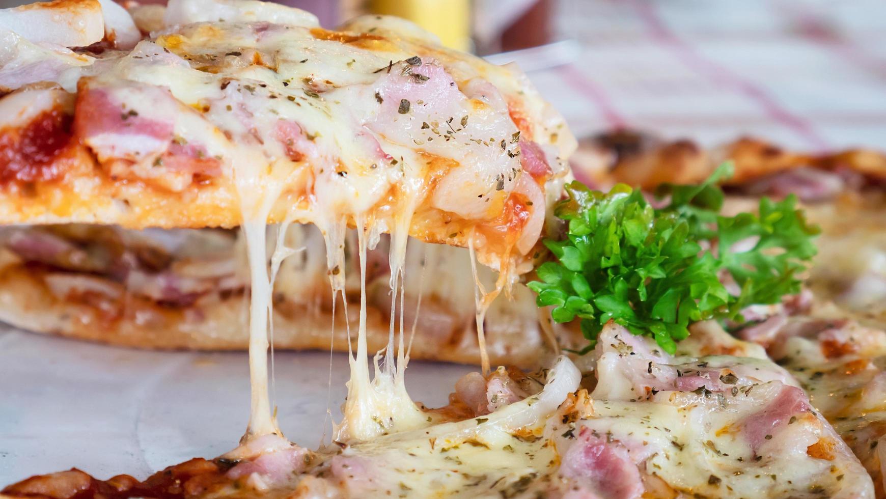 Almuerzo familiar comiendo pizza receta de jamón y queso - gente con favor concepto de plato italiano foto