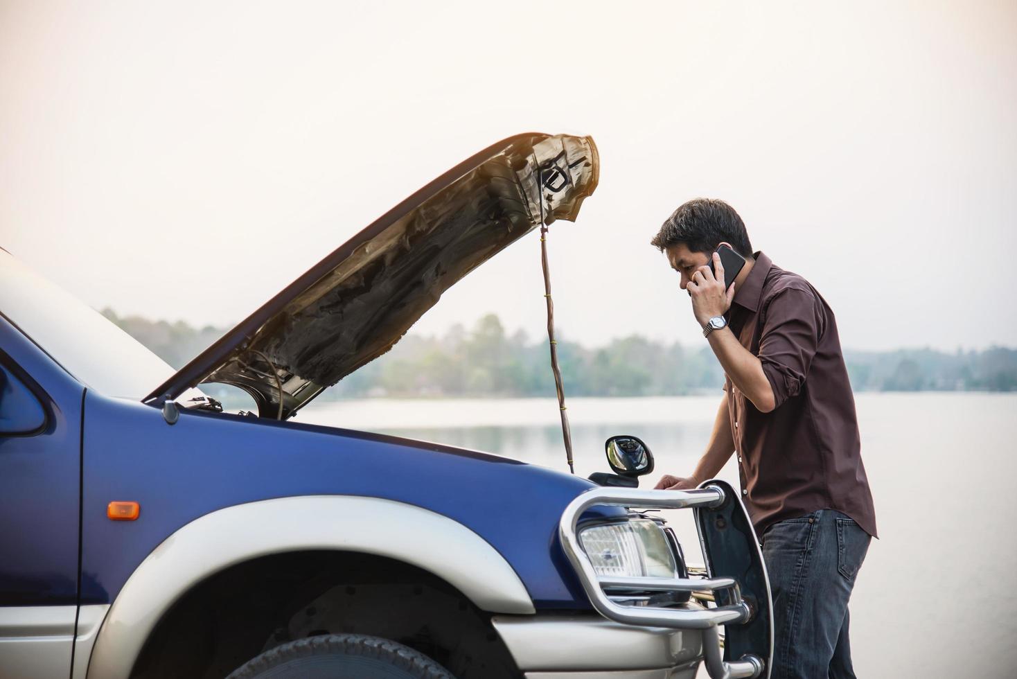 Man try to fix a car engine problem on a local road Chiang mai Thailand - people with car problem transportation concept photo