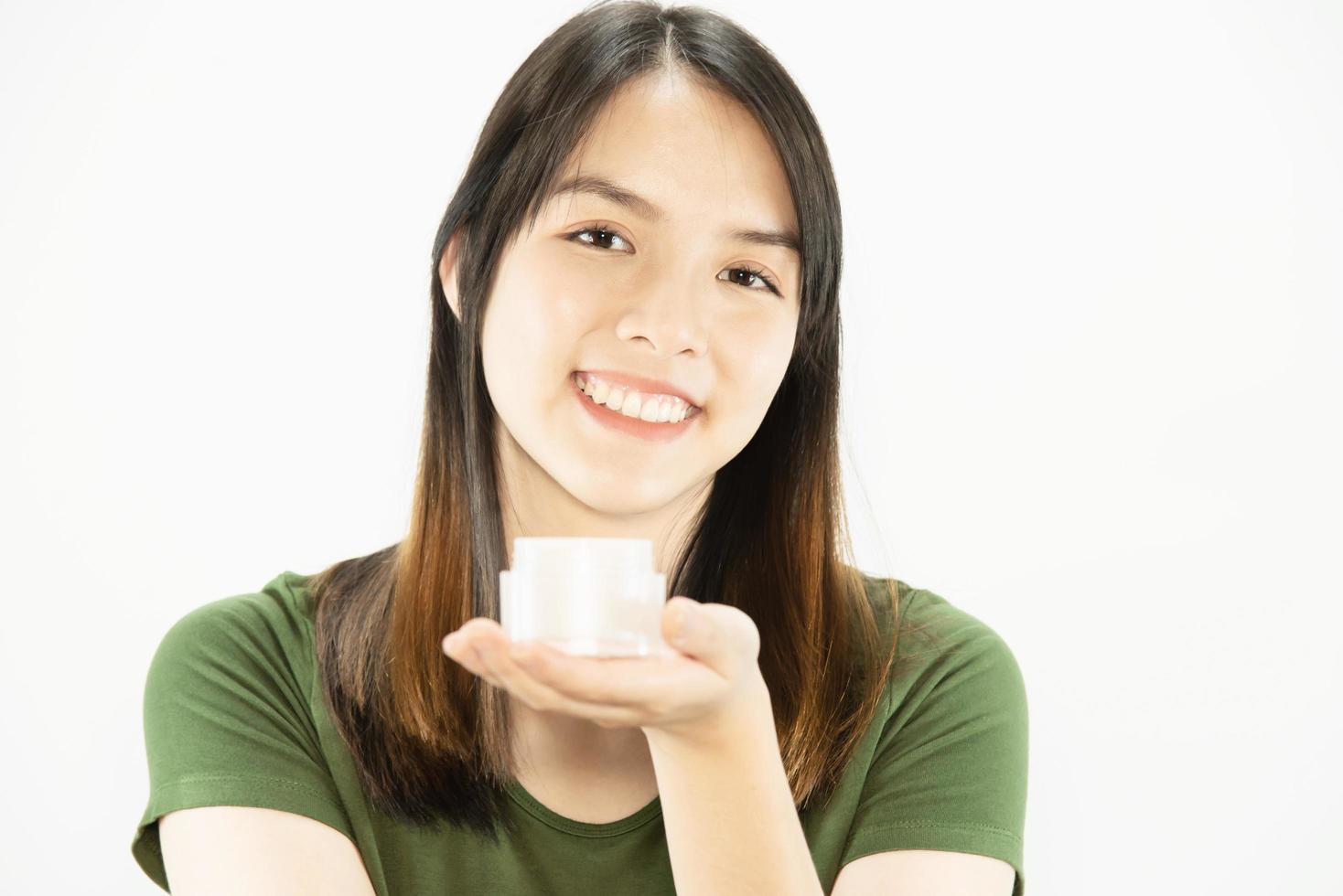 Young beautiful lady using moisturizer cream for face skin care - woman and cosmetic makeup face beauty skin care concept photo