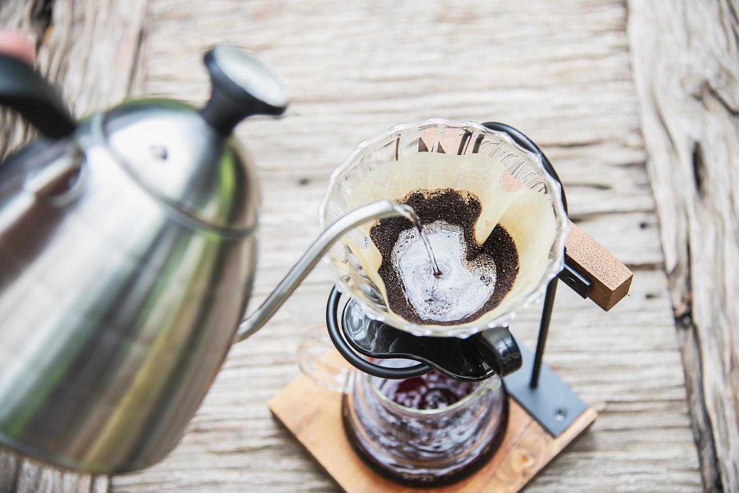 Man making drip fresh coffee in vintage coffee shop with green nature background - people with fresh coffee in nature concept photo