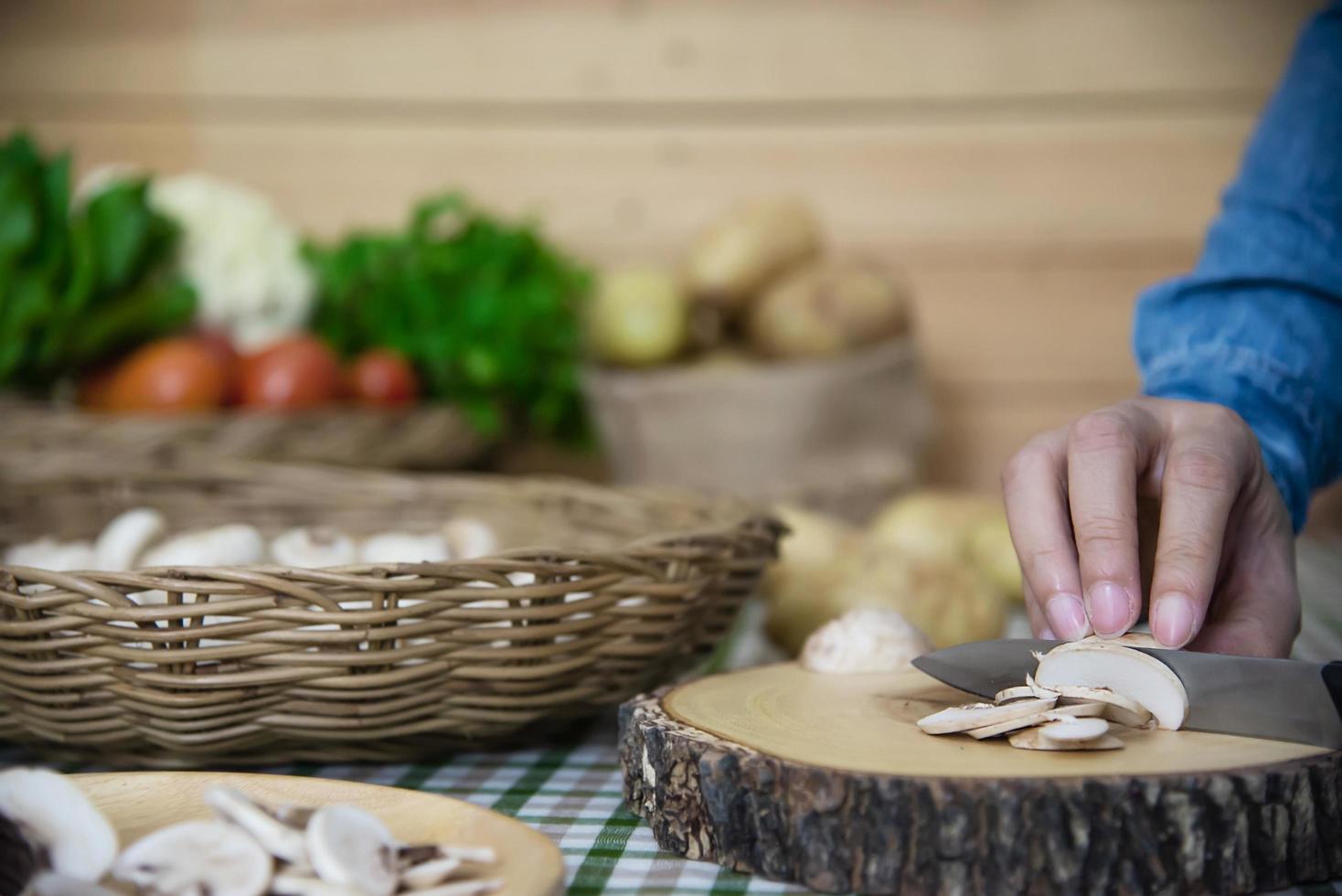 señora cocina champiñón fresco vegetal en la cocina - personas con concepto de cocina vegetal foto