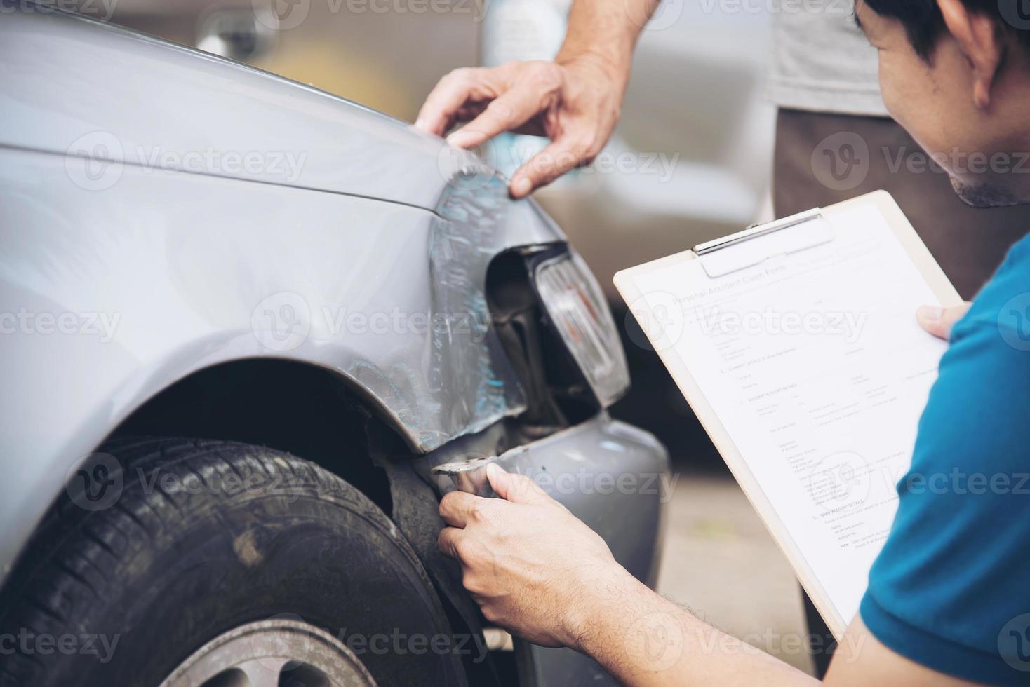 agente de seguros que trabaja durante el proceso de reclamación de accidentes de coche en el lugar - concepto de reclamación de seguros de personas y coches foto