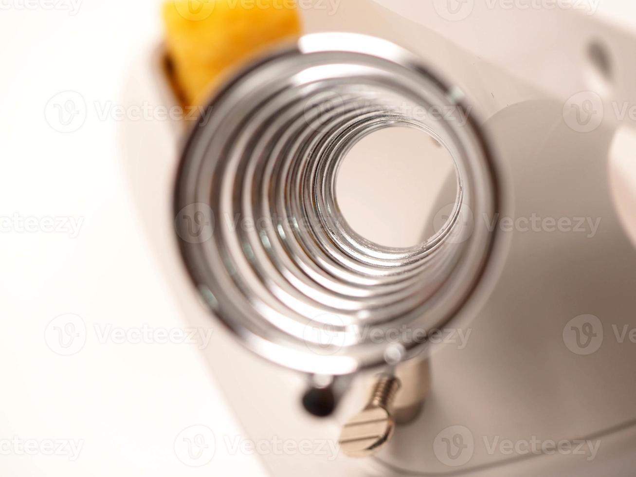 Close up shoot of printed circuit board PCB sitting on a white repair stand with magnifier for better examining small parts photo