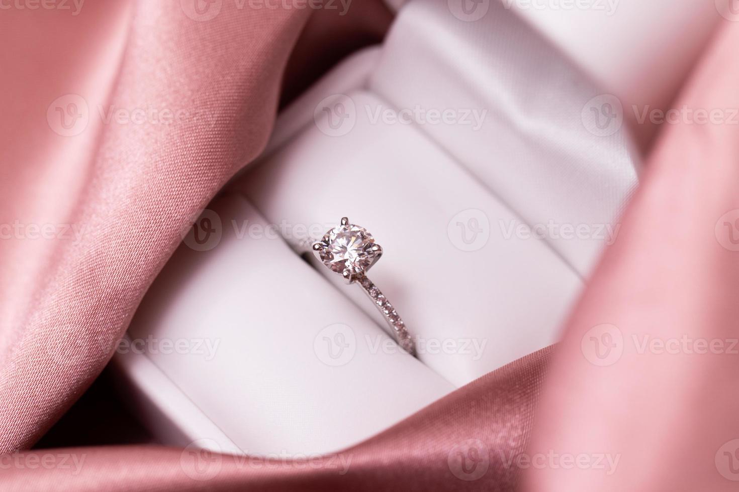 anillo de bodas de diamantes tela rosa foto