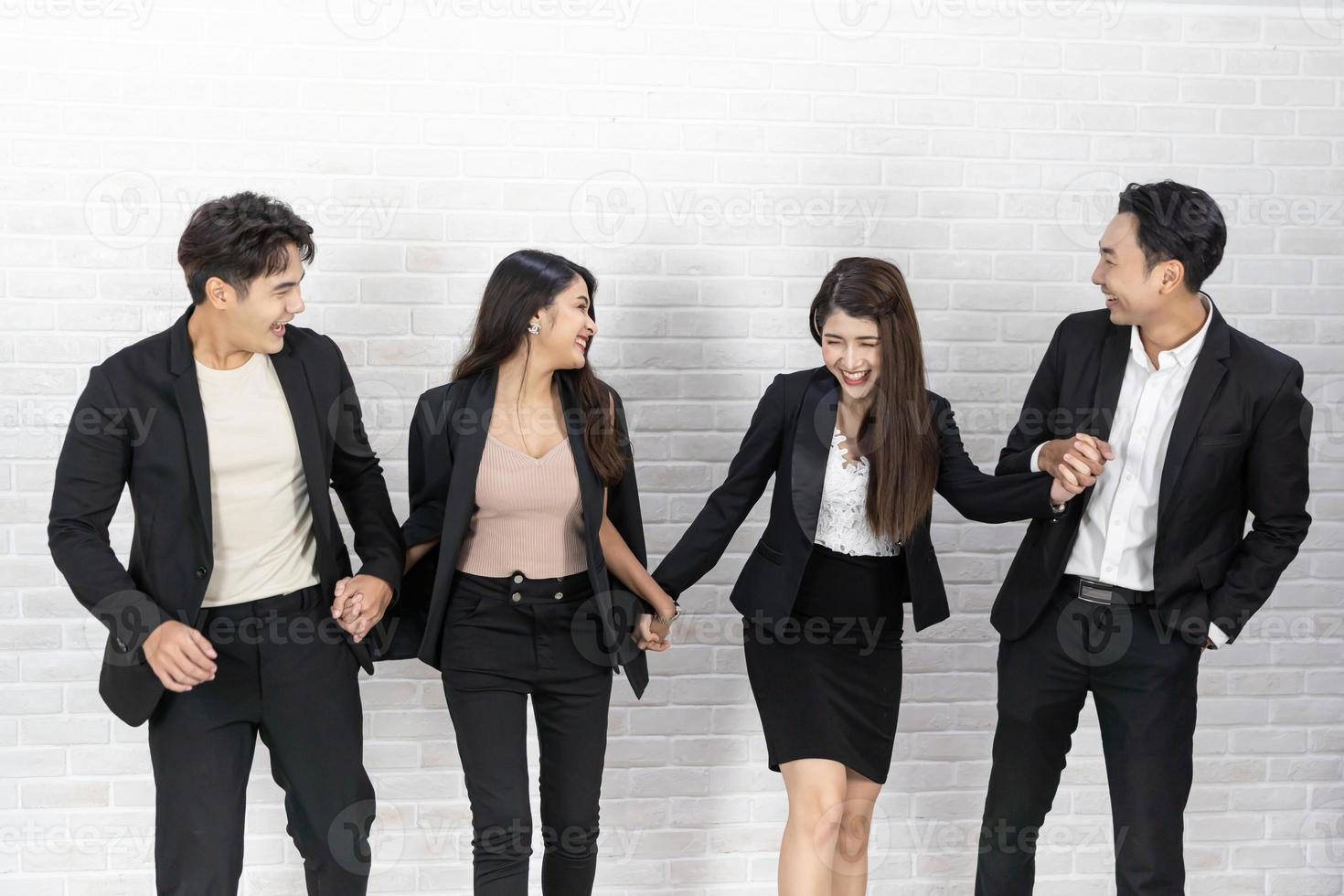 The business people standing on the white wall background. Group Of Happy Business People Standing In Pose Over White Background photo