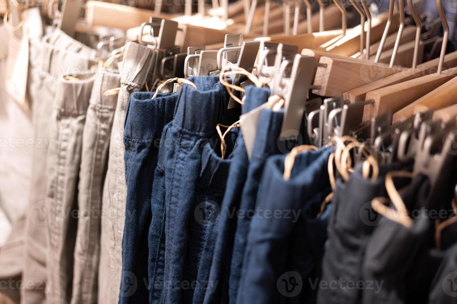 enfoque selectivo, moda, concepto de ropa, ropa o pantalones de muchos colores colgados en un estante en una tienda de ropa de diseñador. muchos colores pastel foto