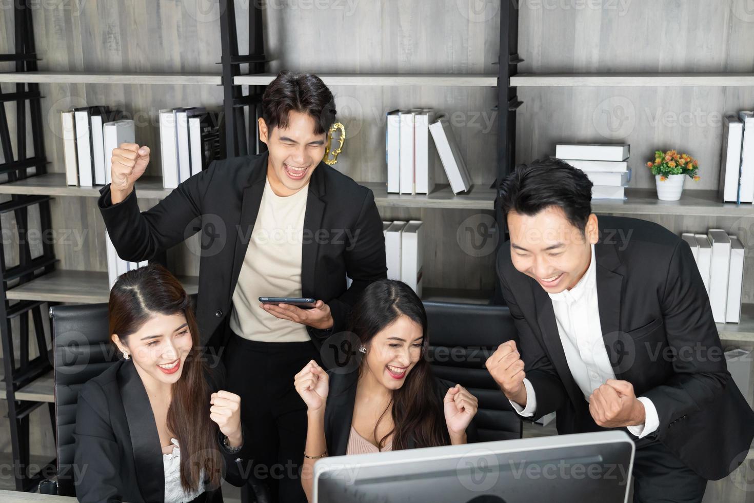 Happy Business People At Computer Celebrating Success At Work Sitting In Modern Office. Successful Negotiations. business team looking at the computer monitor. photo