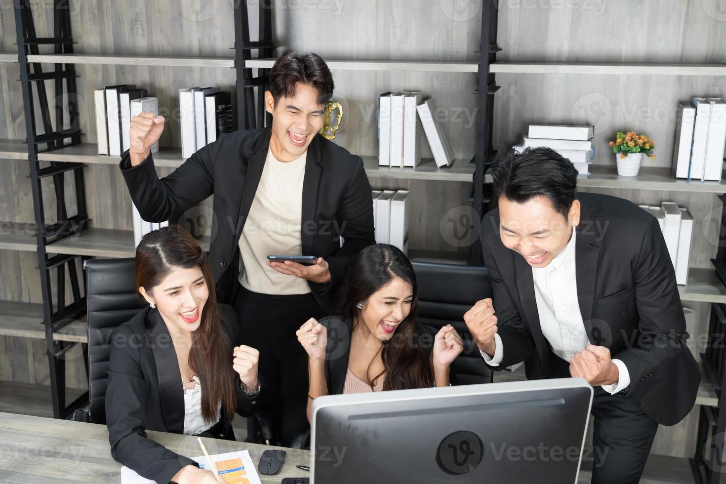 Happy Business People At Computer Celebrating Success At Work Sitting In Modern Office. Successful Negotiations. business team looking at the computer monitor. photo