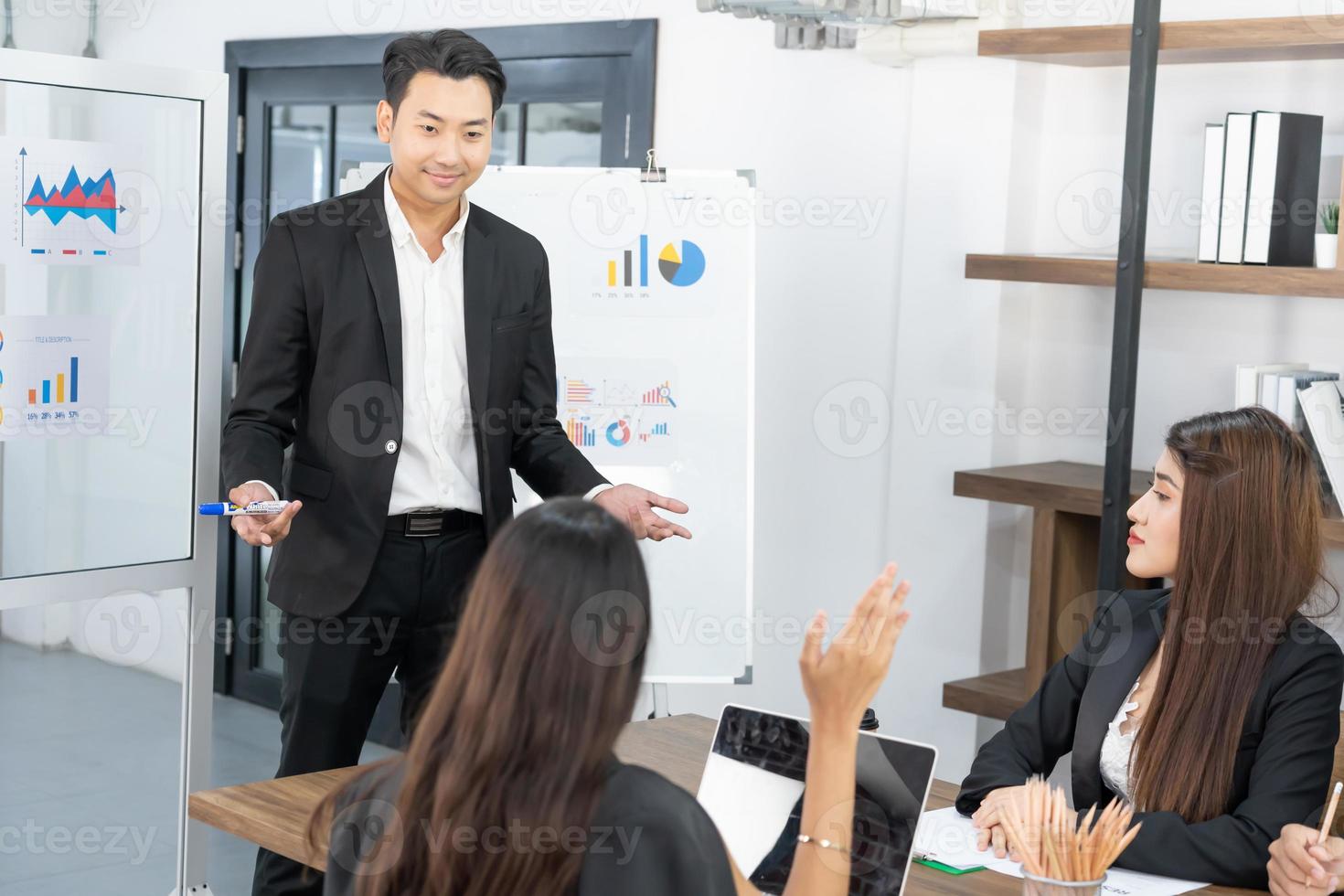 Business presentation. project manager pointing at desktop presenting statistical data, briefing diverse group of employees. demonstrates statistics. photo