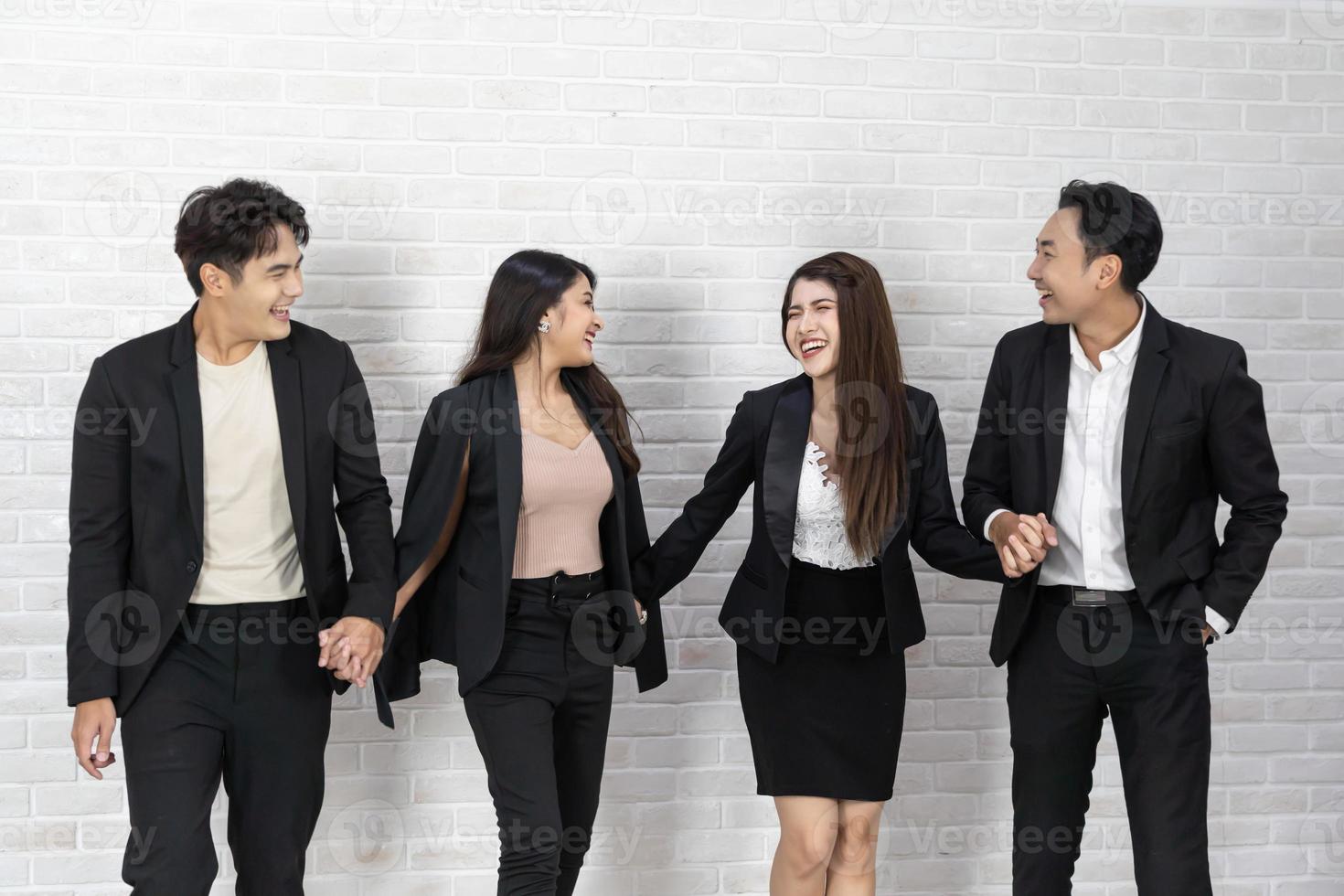 The business people standing on the white wall background. Group Of Happy Business People Standing In Pose Over White Background photo