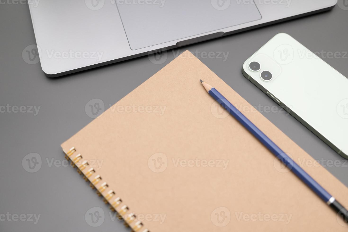 Gray desk office with laptop, smartphone and other work supplies. computer desk with keyboard, smartphone and stationery. copy space for input the text. photo