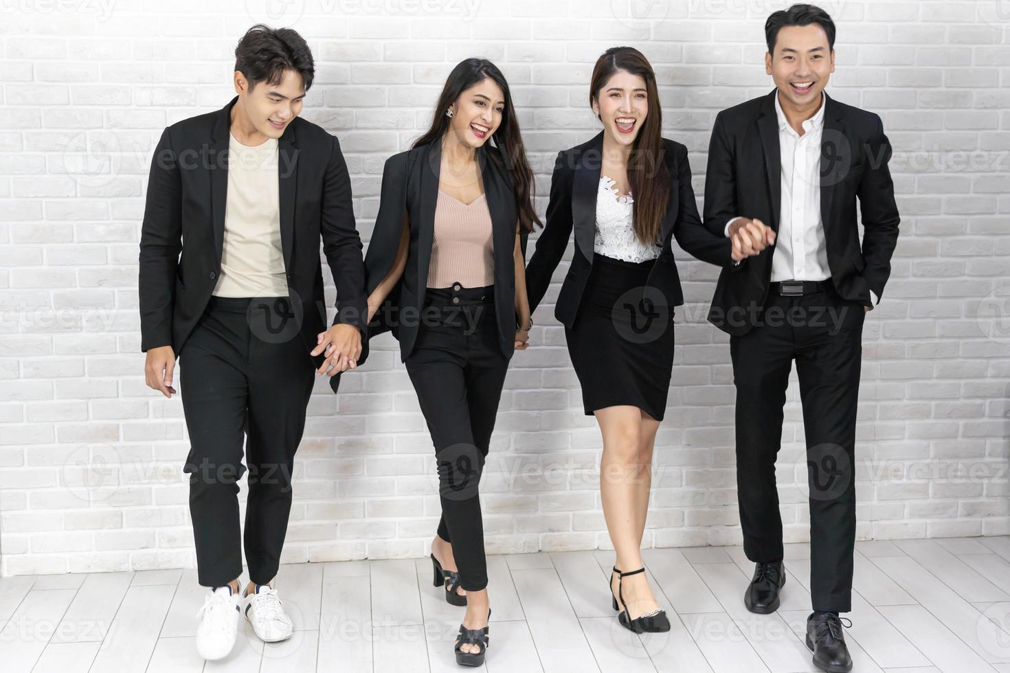 The business people standing on the white wall background. Group Of Happy Business People Standing In Pose Over White Background photo