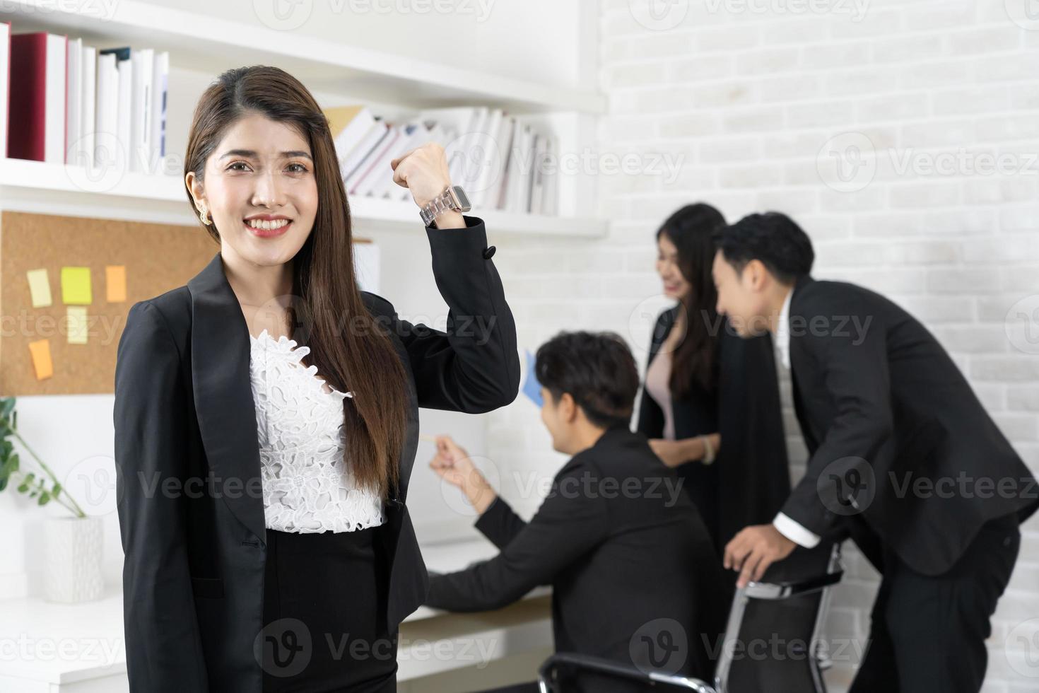 Beautiful professional Asian business woman smiles happily successful while looking at the camera. business woman is standing and cheerful with proud of her success photo