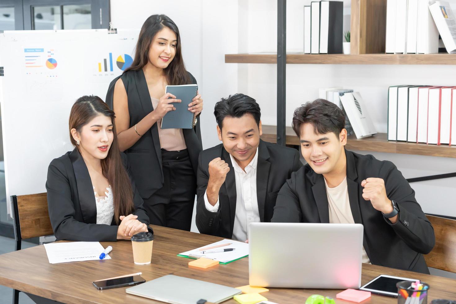 Happy Business People At Computer Celebrating Success At Work Sitting In Modern Office. Successful Negotiations. business team looking at the computer monitor. photo