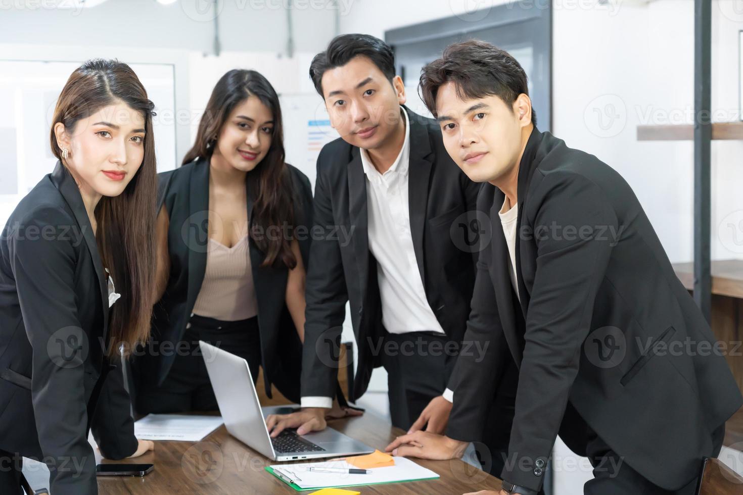 un equipo de negocios asiático confiado se encuentra en el cargo. la gente del equipo de oficina multicultural profesional feliz recomienda la mejor empresa. de pie juntos foto